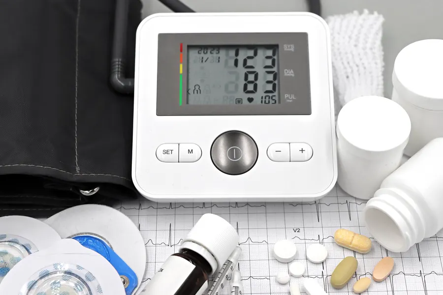 A digital blood pressure monitor showing a normal reading