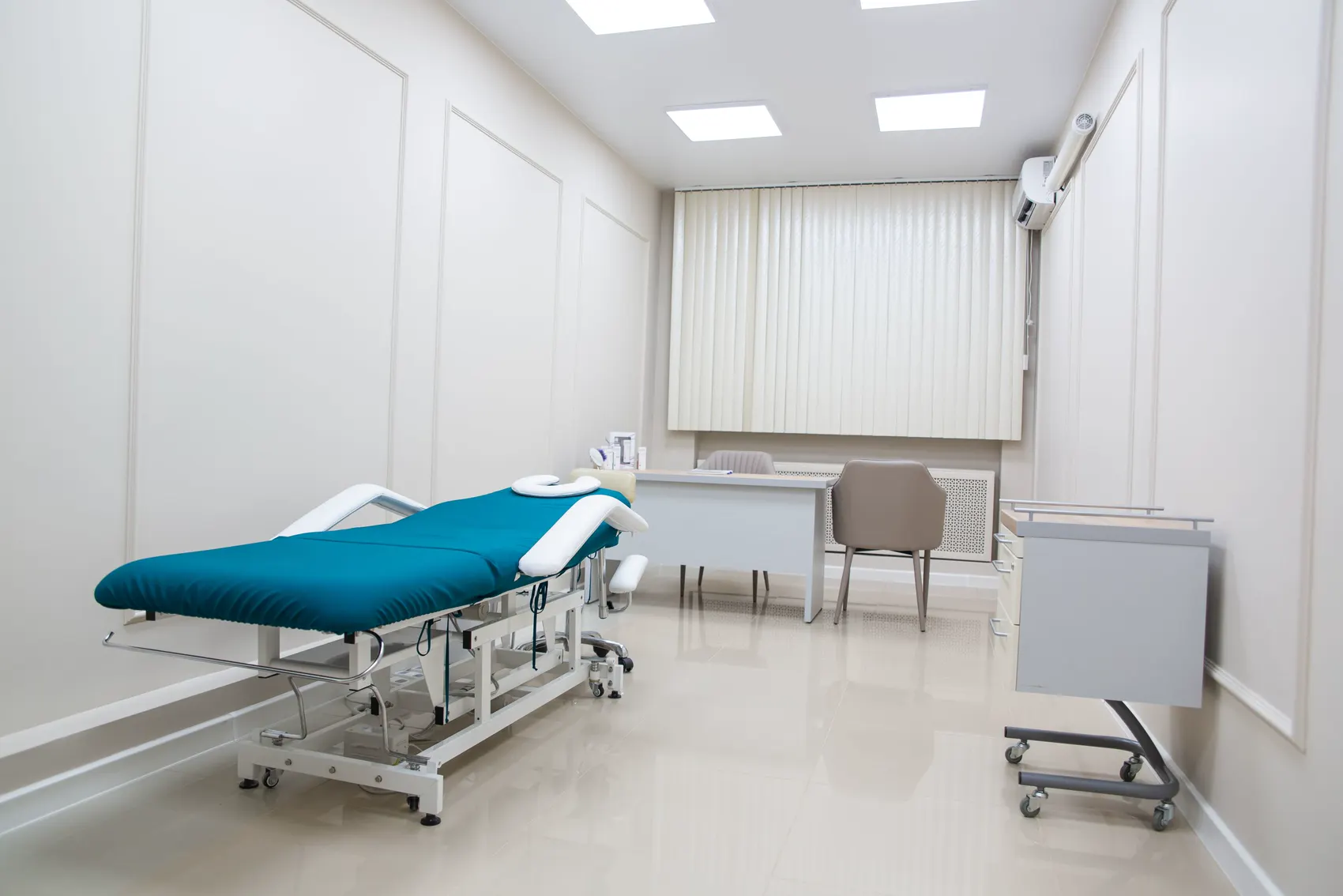 The examination room: a teal couch under bright ceiling lights